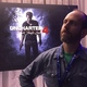 Uncharted 4 game director Bruce Straley strikes a pose in front of a poster for Nathan Drake's latest adventure.